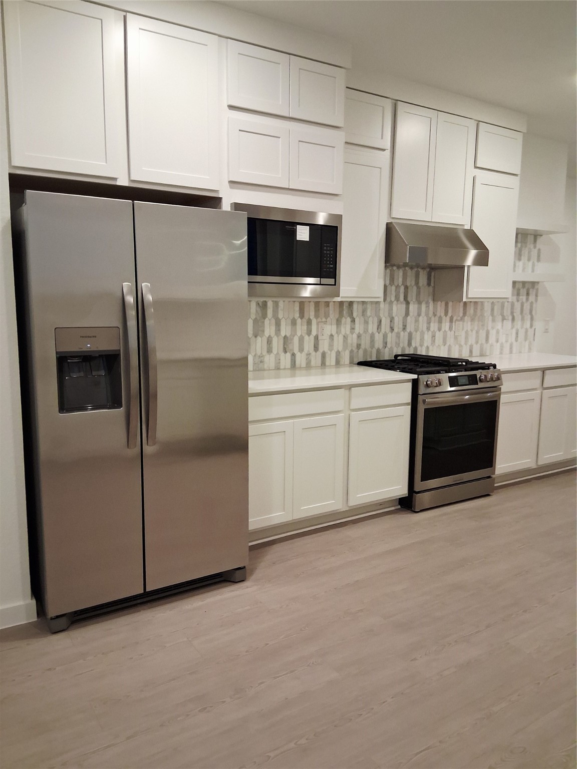 1047 Blue Stone Drive Beasley, TX 77417 - Photo 5 of 11 a kitchen with stainless steel appliances granite countertop a stove and a microwave