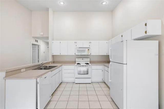 a kitchen with white cabinets and white appliances