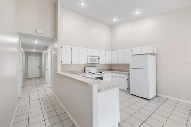a kitchen with white cabinets and white appliances