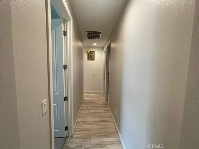 a view of a hallway with wooden floor