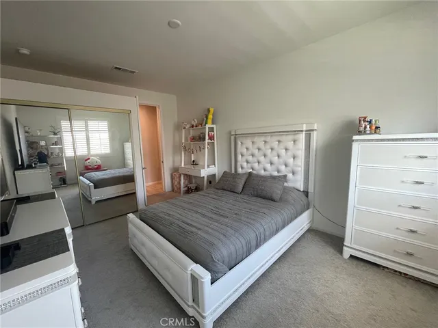 a spacious bedroom with a bed and couch