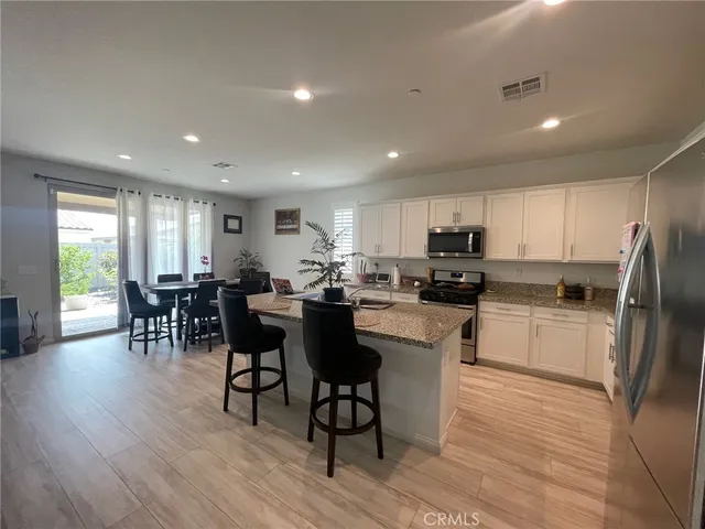 a kitchen with a dining table chairs appliances and cabinets