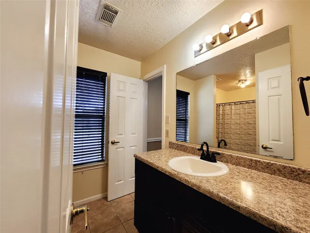 a bathroom with a granite countertop sink and a mirror