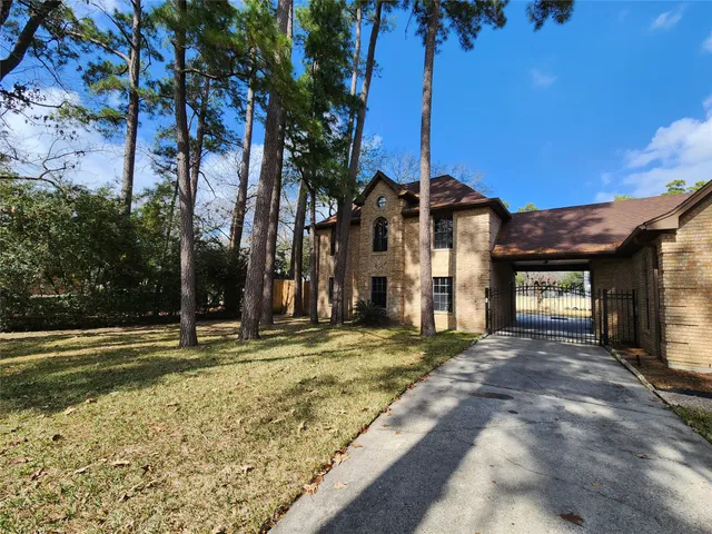 a view of a house with a yard and large tree