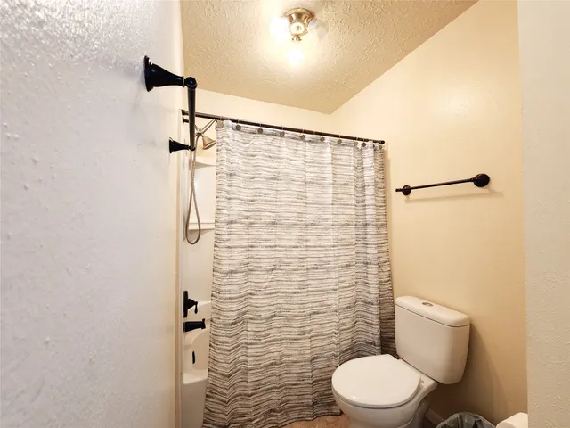 a bathroom with a toilet and a shower