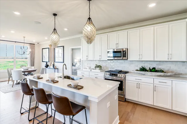 a kitchen with a stove a center island a dining table and chairs