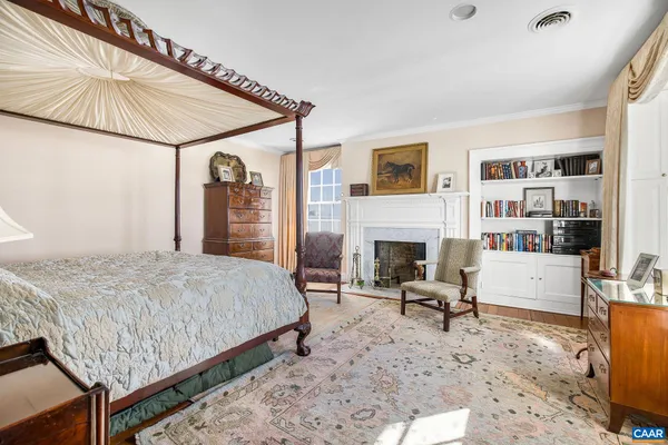 a bedroom with a bed and a fireplace with wooden floor