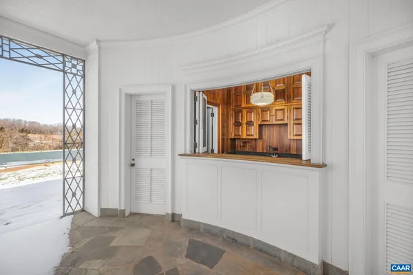 a view of an empty room with a floor to ceiling window and a lake view