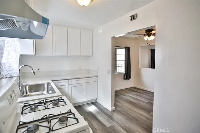 a kitchen with a stove and a white cabinet