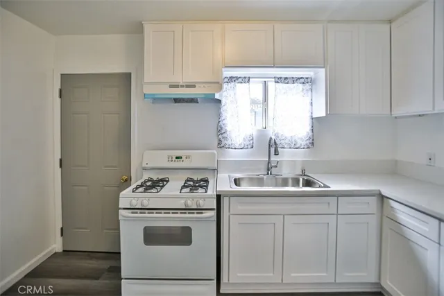 a kitchen with white cabinets and white appliances