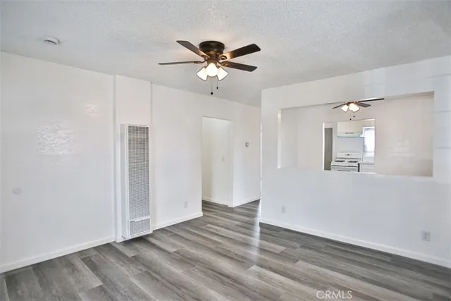 a view of a livingroom with wooden floor and a ceiling fan