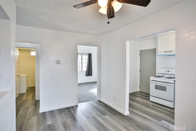 a view of a livingroom with wooden floor and a ceiling fan