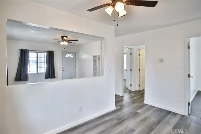 a view of a hallway with wooden floor and chandelier