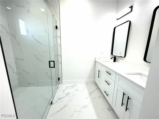a bathroom with double vanity sink and a mirror