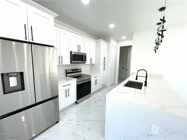 a kitchen with stainless steel appliances a refrigerator sink and microwave