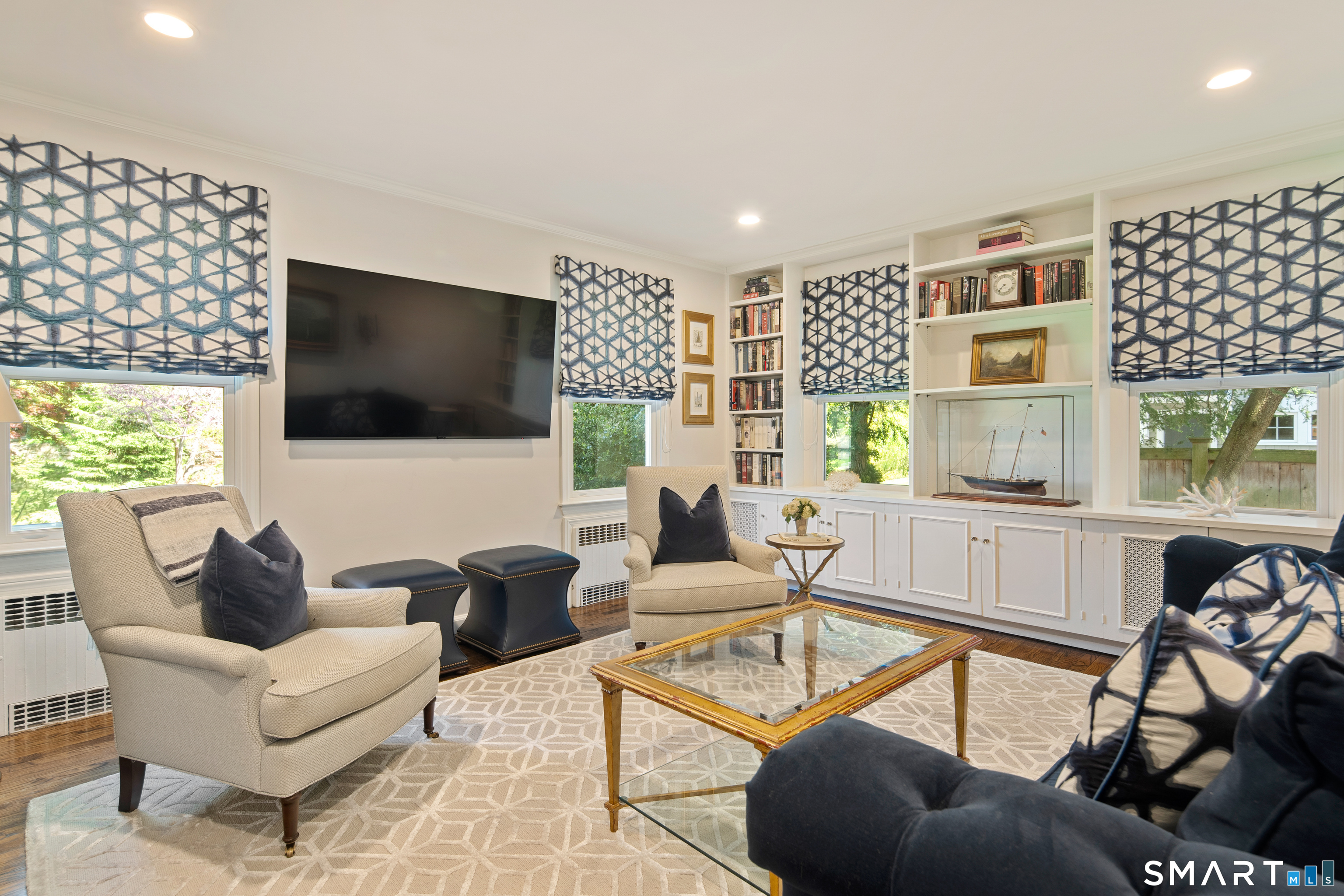 11 McLaren Road South Darien, CT 06820 - Photo 21 of 40 a living room with furniture a flat screen tv and a floor to ceiling window