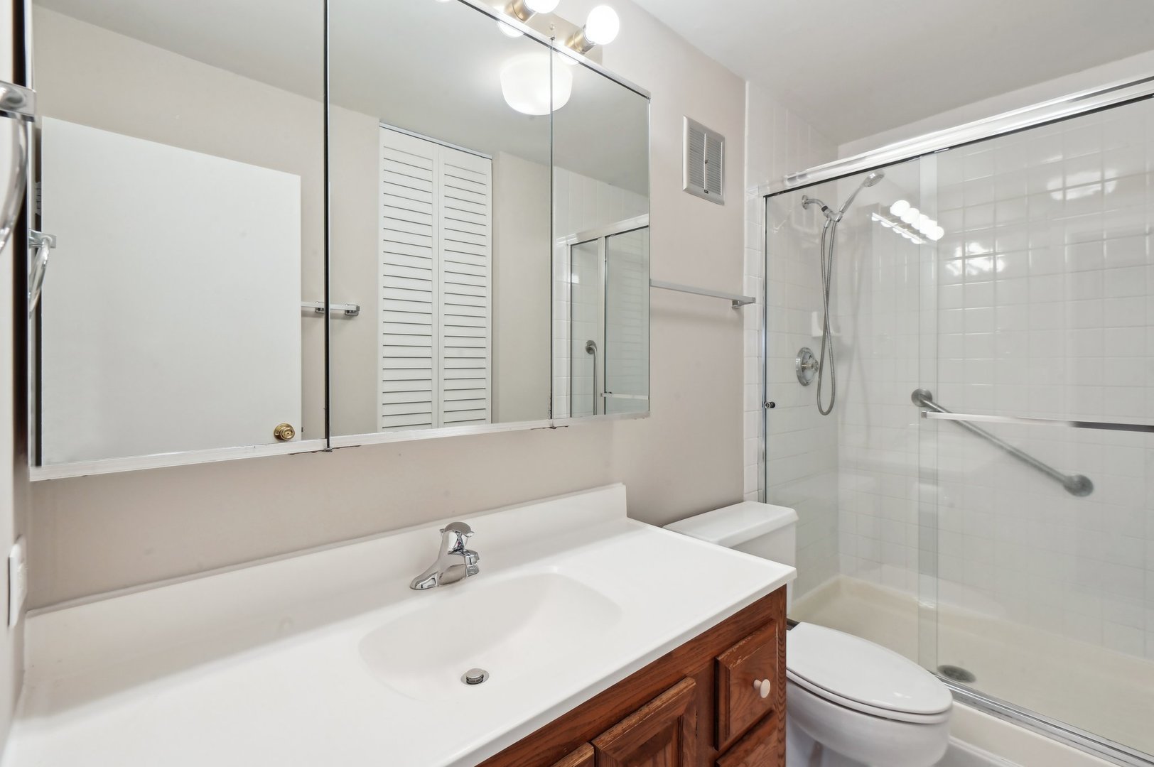 1615 East Central Road, Unit 121C Arlington Heights, IL 60005 - Photo 15 of 23 a bathroom with a sink toilet a mirror and shower