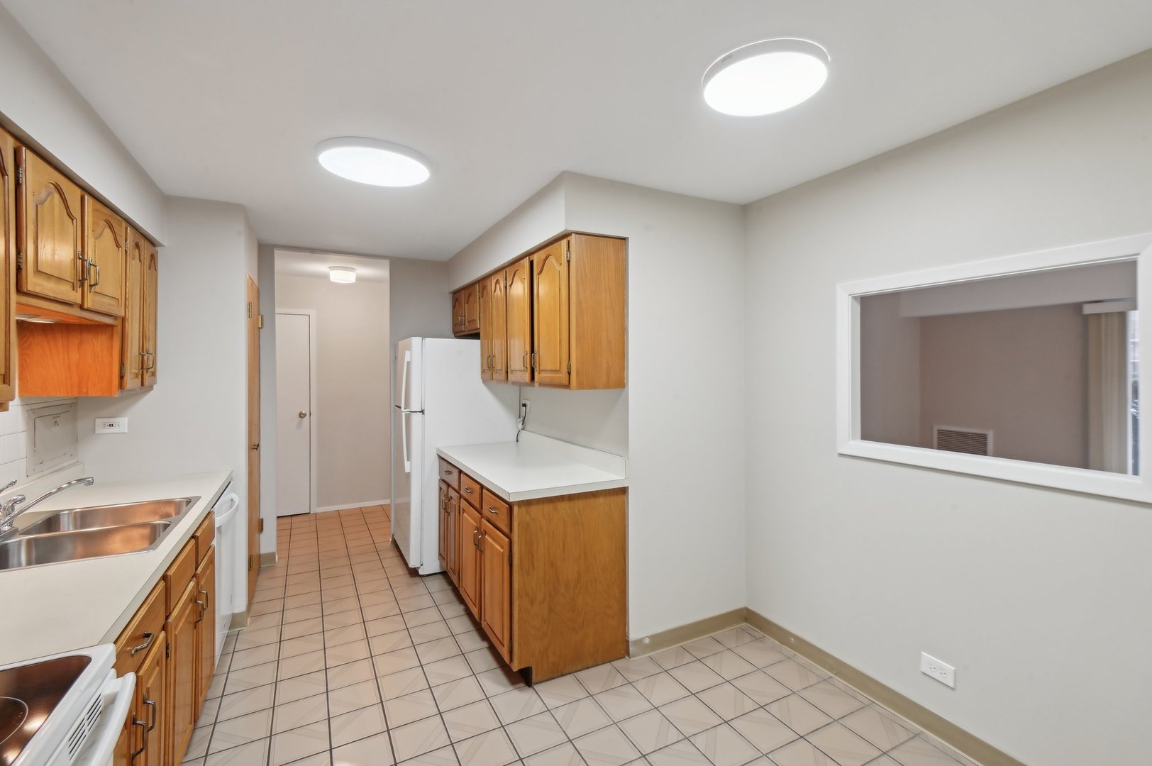 1615 East Central Road, Unit 121C Arlington Heights, IL 60005 - Photo 8 of 23 a kitchen with a stove a sink and a refrigerator
