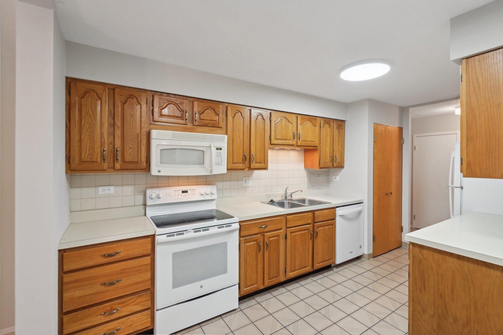 1615 East Central Road, Unit 121C Arlington Heights, IL 60005 - Photo 9 of 23 a kitchen with a sink stove and cabinets