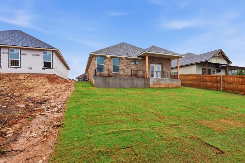 1413 Ridgeview Circle Granbury, TX 76048 - Photo 27 of 35 Rear exterior featuring a covered patio with metal railings, a brick facade, and dual glass panel doors
