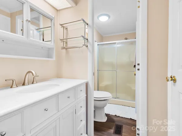 a bathroom with a sink toilet a mirror and shower