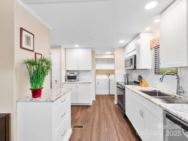 a kitchen with sink a microwave and cabinets