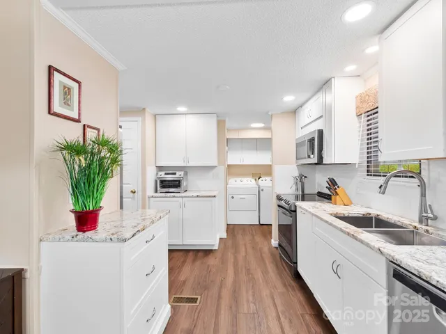 a kitchen with sink a microwave and cabinets