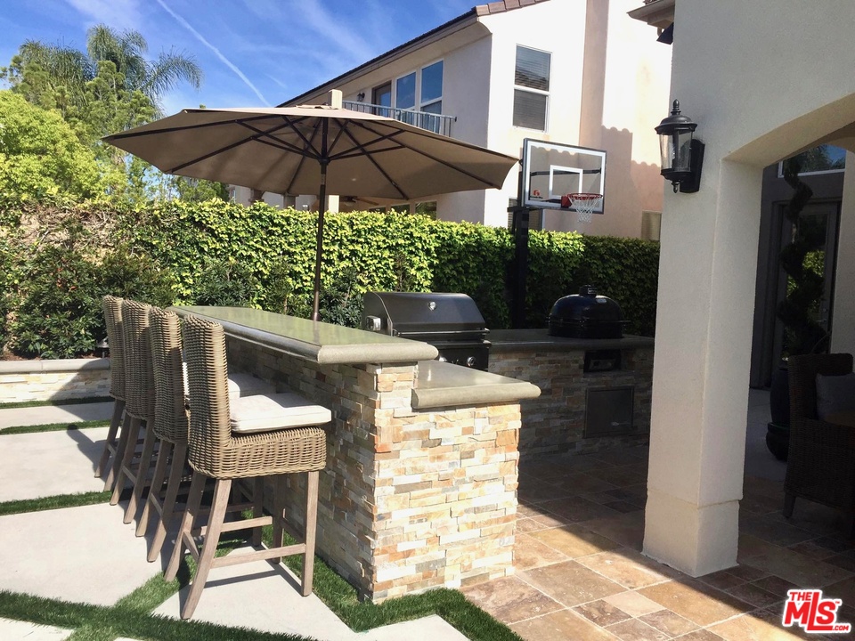 26810 Kendall Lane Stevenson Ranch, CA 91381 - Photo 6 of 44 a patio with table and chairs under an umbrella