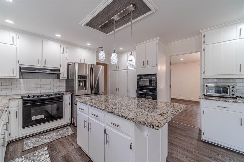 492 New Hope Road Lawrenceville, GA 30046 - Photo 11 of 48 a kitchen with stainless steel appliances granite countertop a stove top oven a sink and a refrigerator
