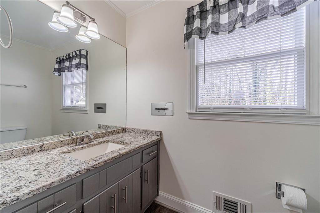 492 New Hope Road Lawrenceville, GA 30046 - Photo 16 of 48 a bathroom with a granite countertop sink a mirror and a window
