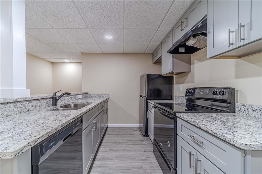 492 New Hope Road Lawrenceville, GA 30046 - Photo 32 of 48 a kitchen with stainless steel appliances granite countertop a sink stove and cabinets