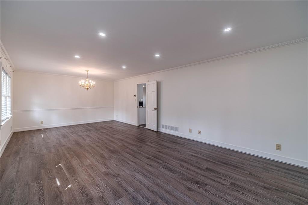 492 New Hope Road Lawrenceville, GA 30046 - Photo 7 of 48 a view of an empty room with wooden floor and a window