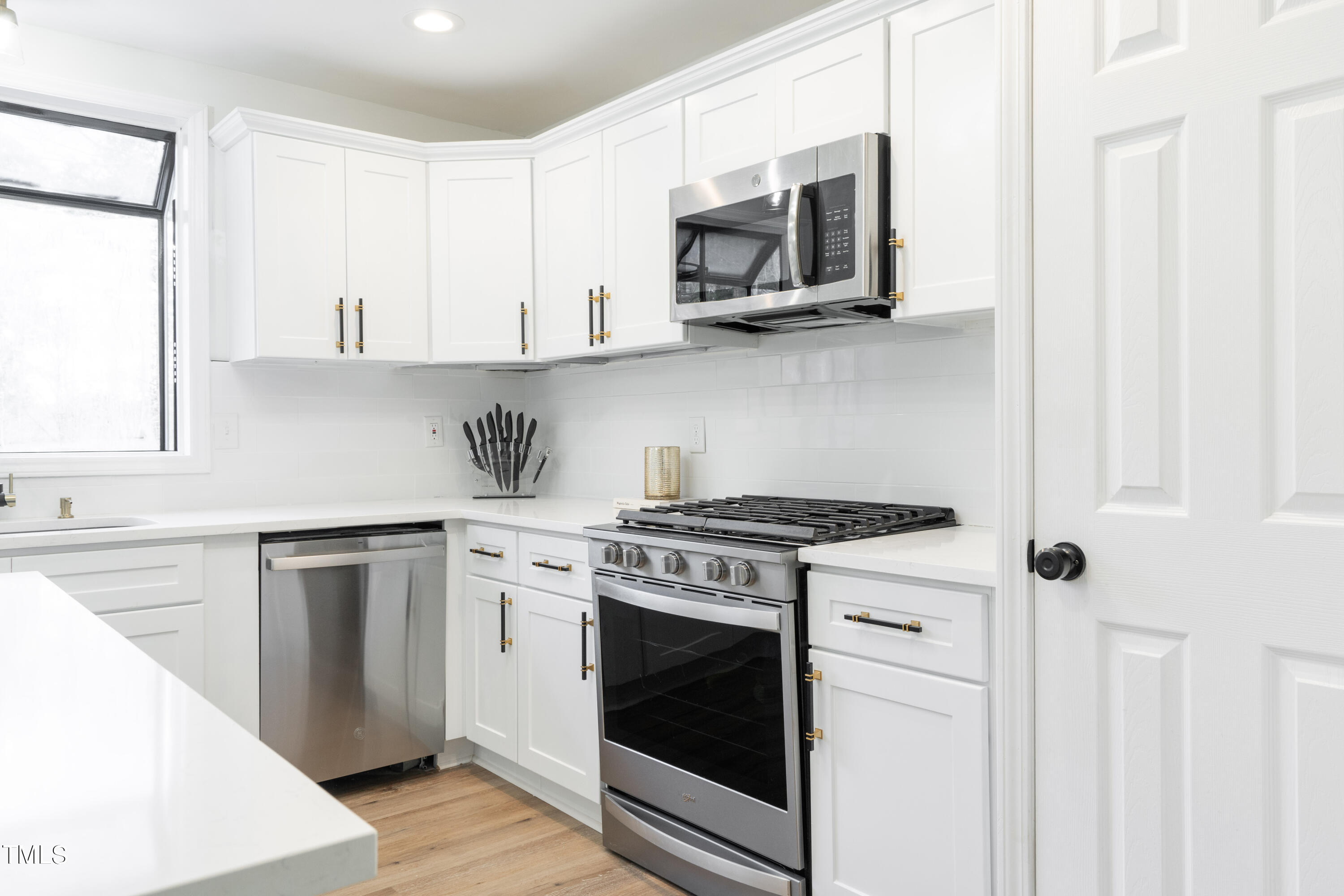 5017 Robinwood Road Durham, NC 27713 - Photo 12 of 45 a kitchen with stainless steel appliances white cabinets and a stove top oven