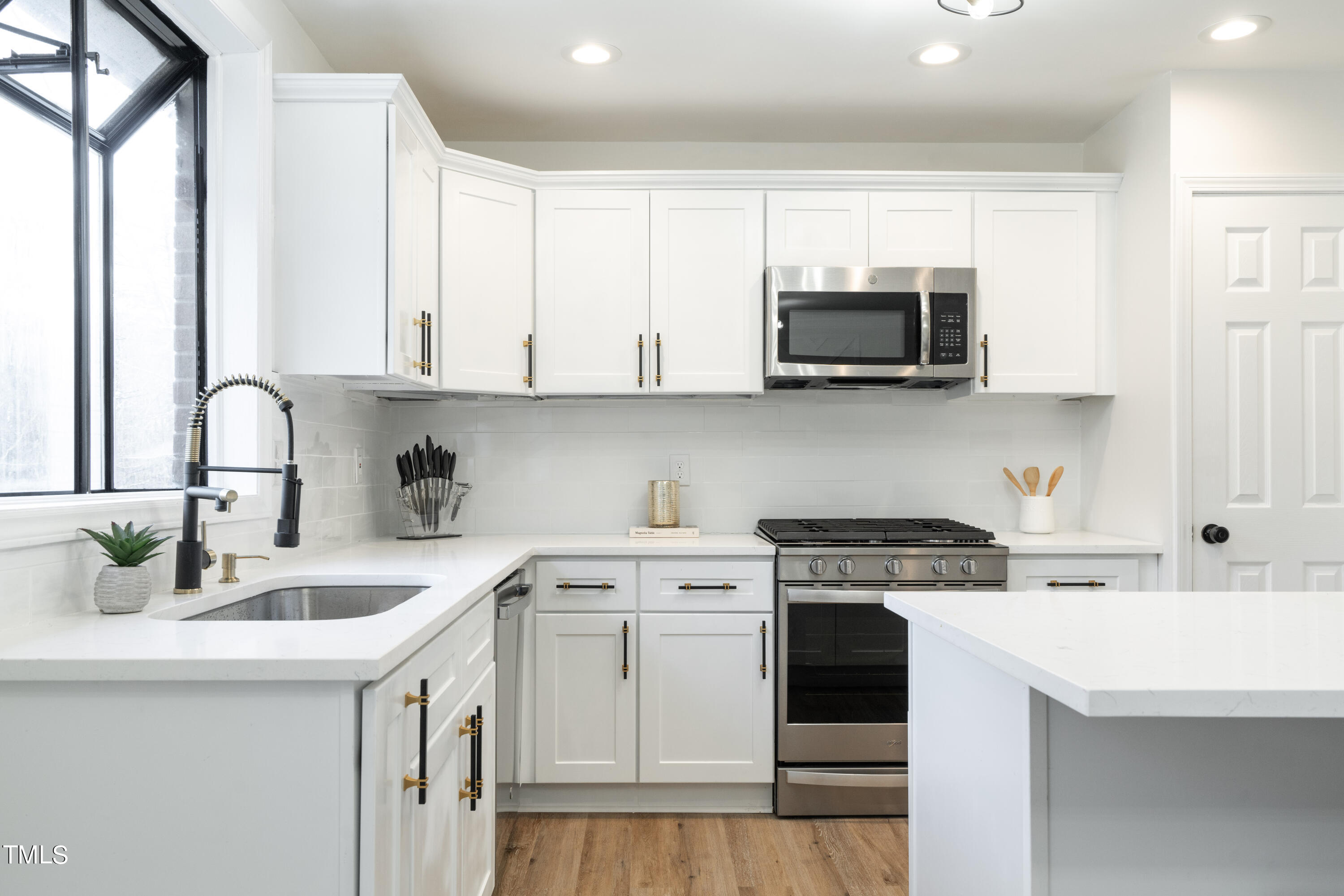 5017 Robinwood Road Durham, NC 27713 - Photo 10 of 45 a kitchen with stainless steel appliances granite countertop a sink a stove a microwave and cabinets