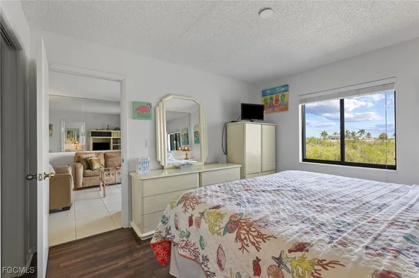 a bed sitting in a spacious bedroom next to a window