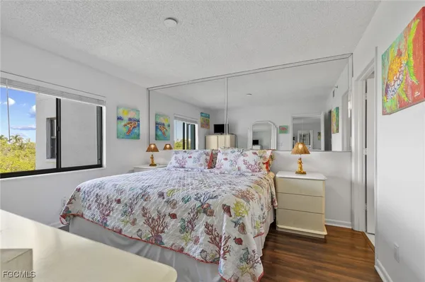 a bedroom with a large bed a mirror and dresser