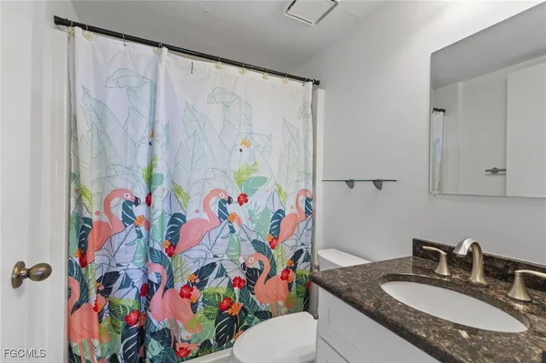 a bathroom with a sink a toilet and shower curtain
