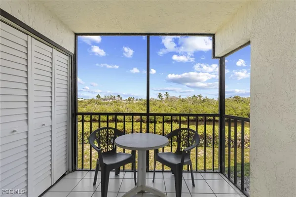 a view of a balcony with chairs and a potted plant