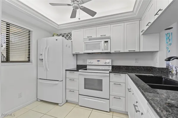 a kitchen with white cabinets and white appliances