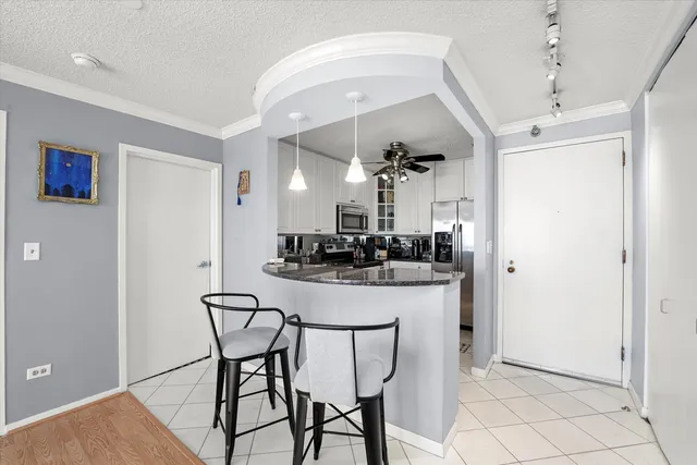 a view of a dining room with furniture and a chandelier fan