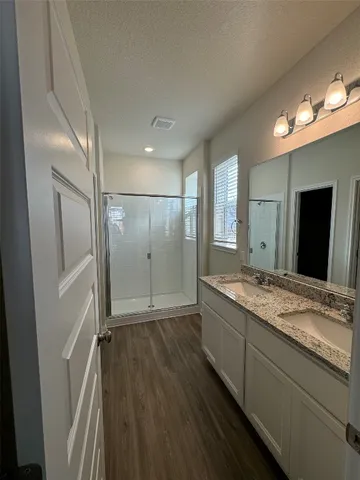 a bathroom with a granite countertop sink mirror and shower