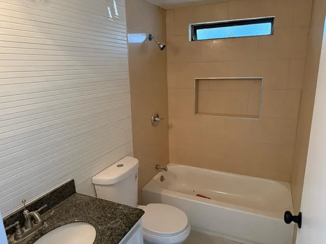 a white toilet and tub sitting next to a bathroom sink
