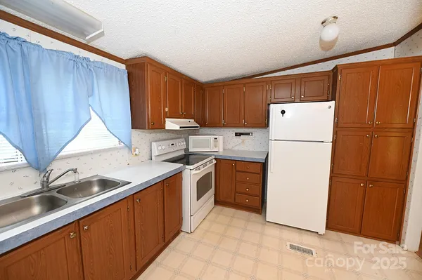 a kitchen with a refrigerator sink and cabinets