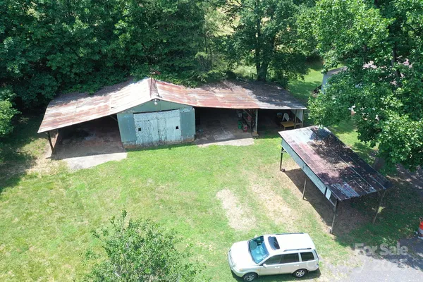 a backyard of a house with large trees and a small yard