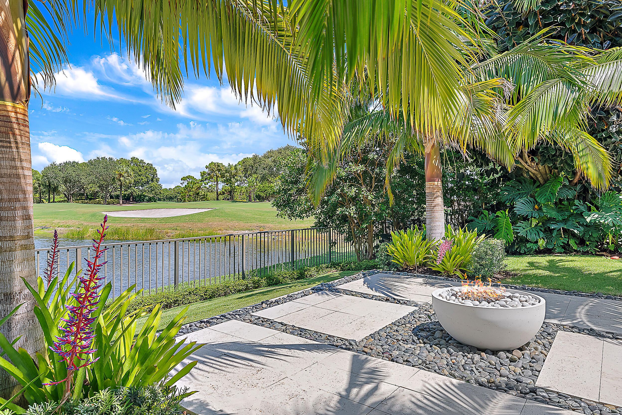 134 Golf Village Boulevard Jupiter, FL 33458 - Photo 28 of 48 a view of a backyard with potted plants and water view