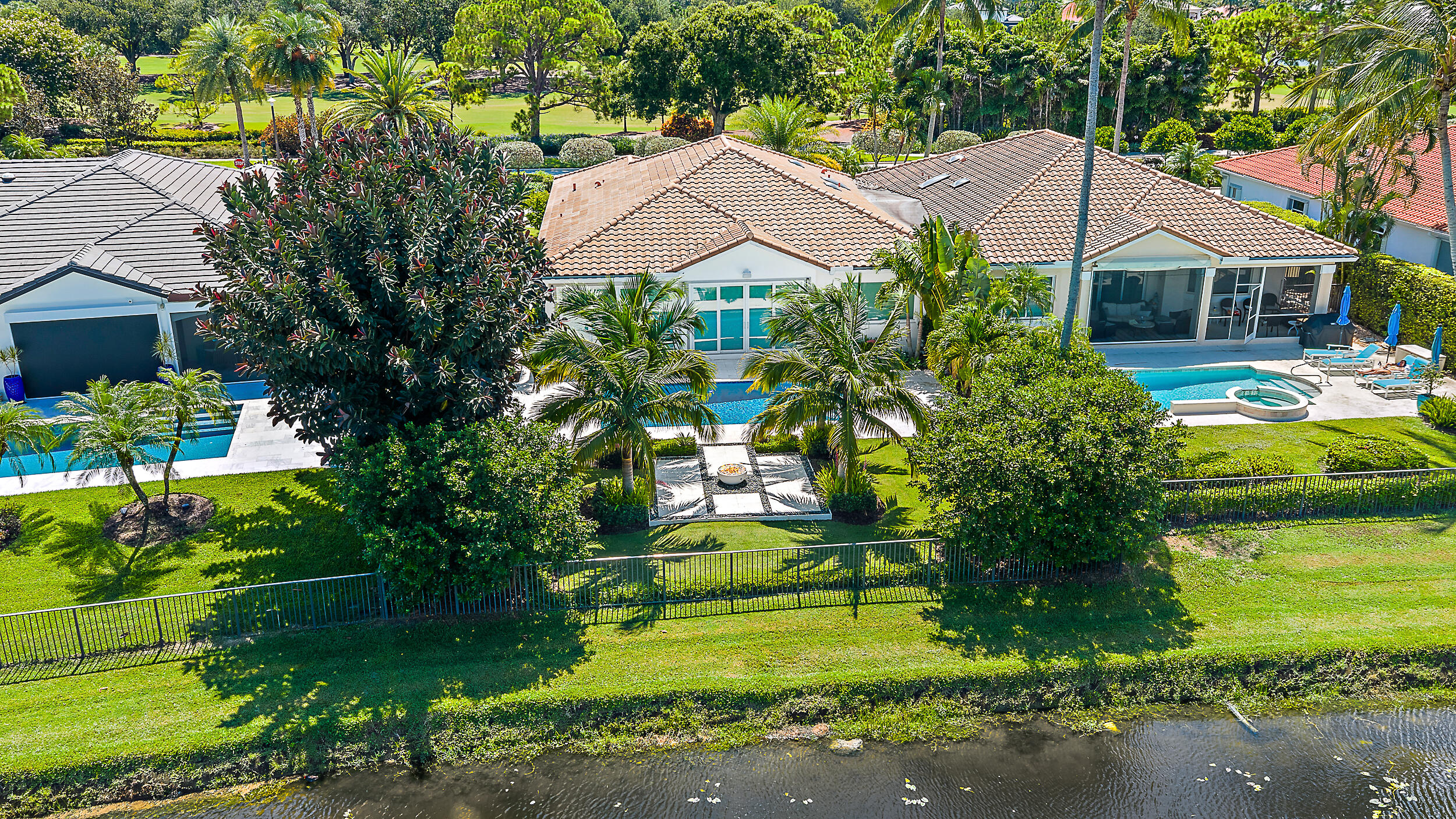 134 Golf Village Boulevard Jupiter, FL 33458 - Photo 31 of 48 a house that has a lot of plants and trees in the background