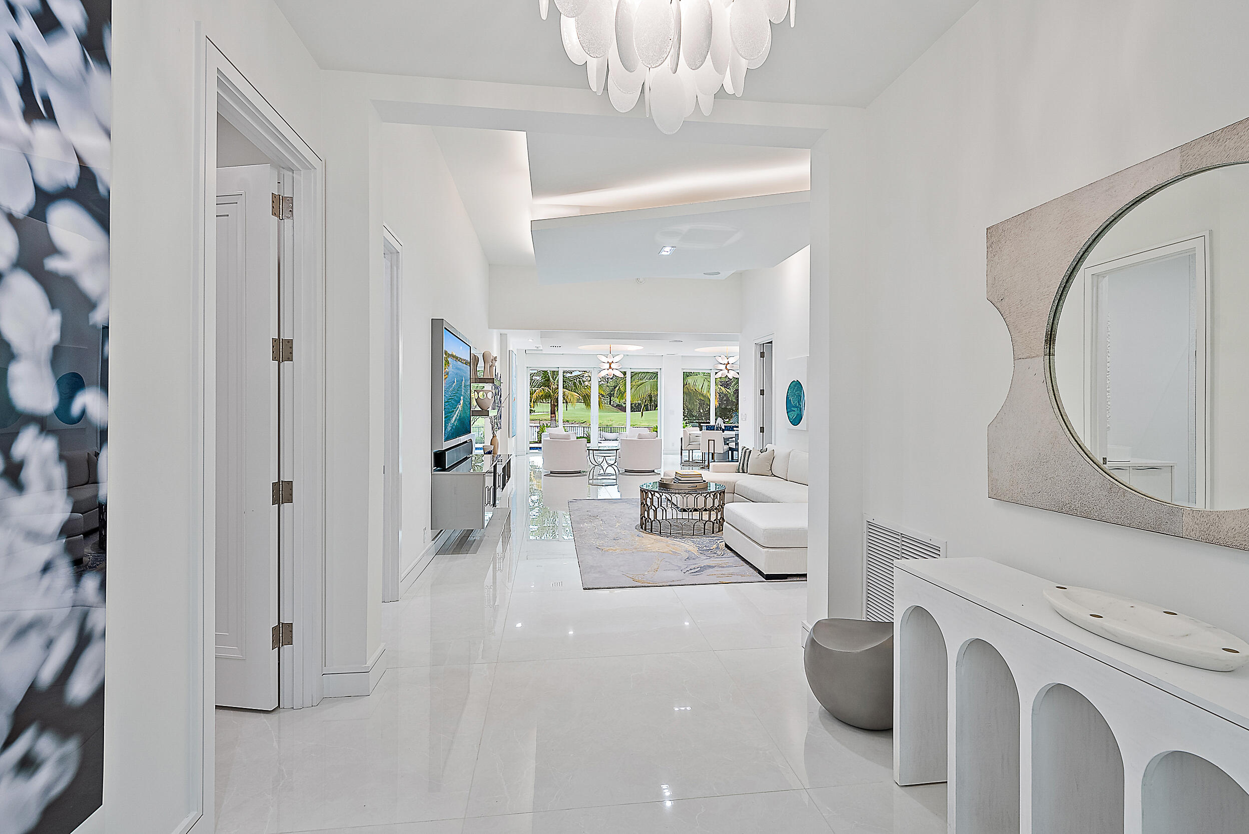 134 Golf Village Boulevard Jupiter, FL 33458 - Photo 6 of 48 a living room with furniture a fireplace and a chandelier