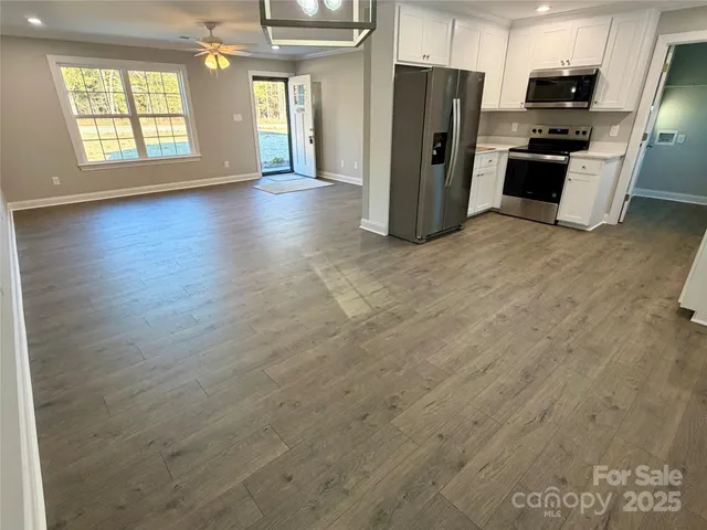 a view of a kitchen with a refrigerator a microwave and a sink