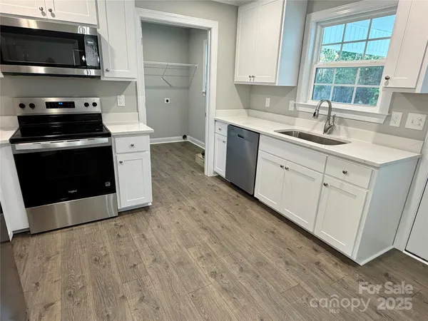 a kitchen with stainless steel appliances a stove a sink a microwave and cabinets