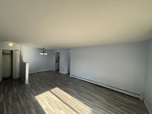 a view of an empty room and wooden floor